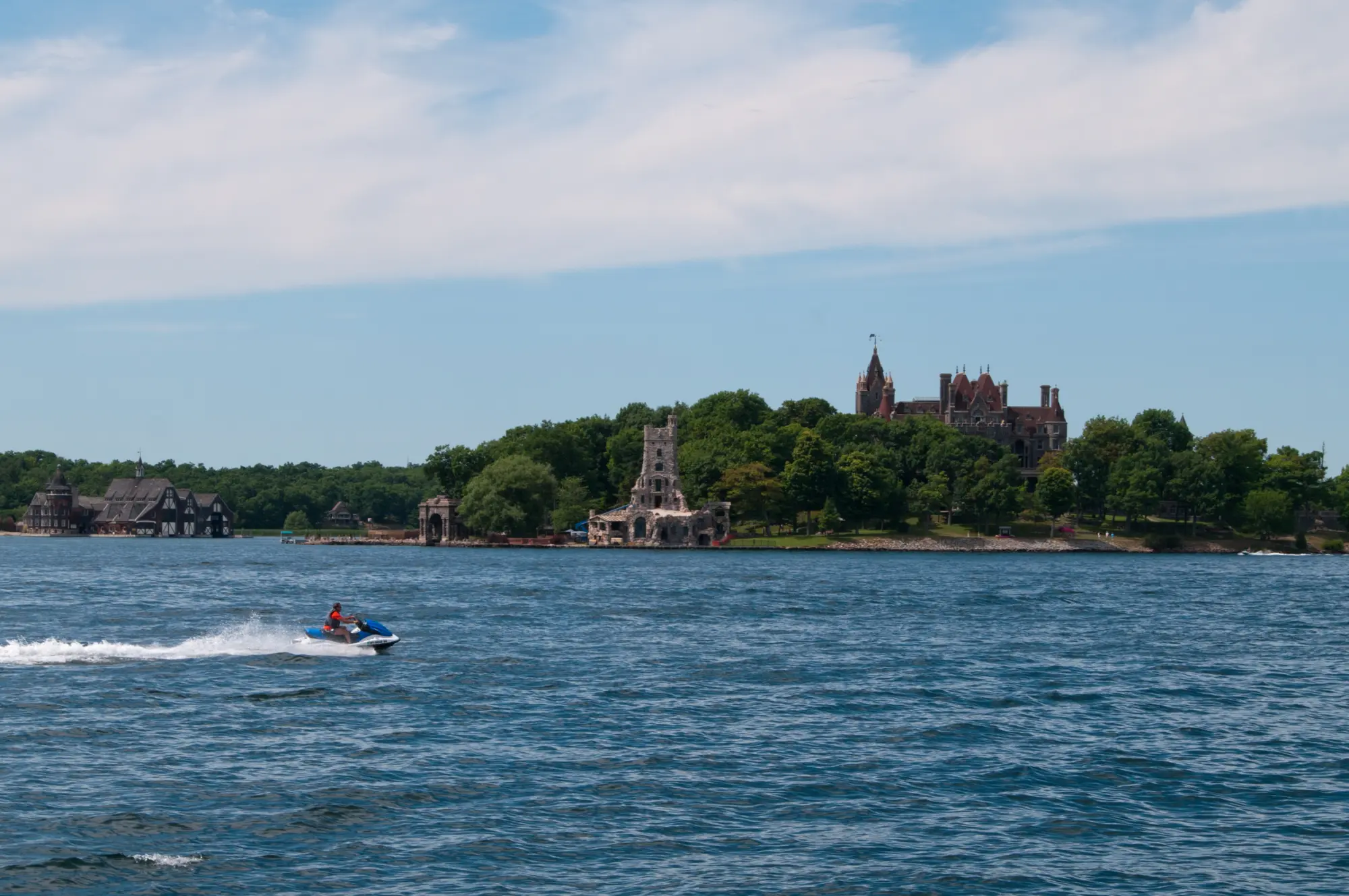 Boldt Castle on Heart Island, seen across the St. Lawrence River from Alexandria Bay, with a jet ski crossing the water