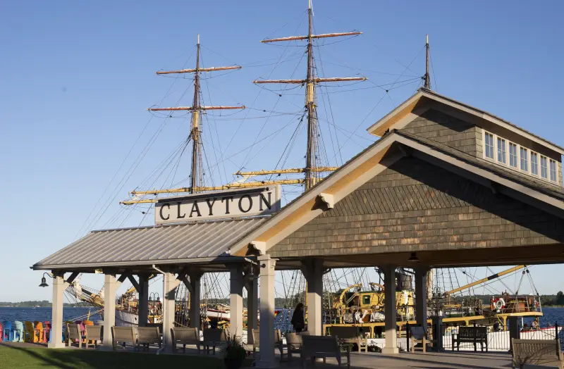 Clayton's waterfront pavilion with the tall masts of a sailing ship behind it