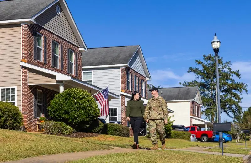 A soldier and spouse walking past on-post family homes