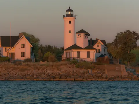 Tibbetts Point Lighthouse at sunset, seen from the water