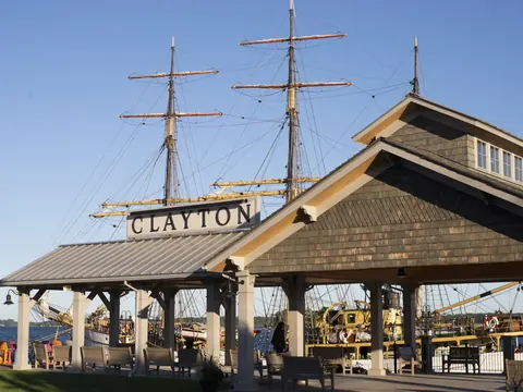 Clayton's waterfront pavilion with the tall masts of a sailing ship behind it